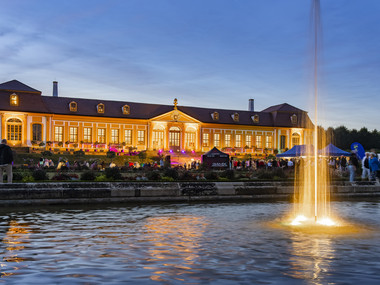 Sie sehen die Obere Orangerie bei einer abendlichen Veranstaltung.